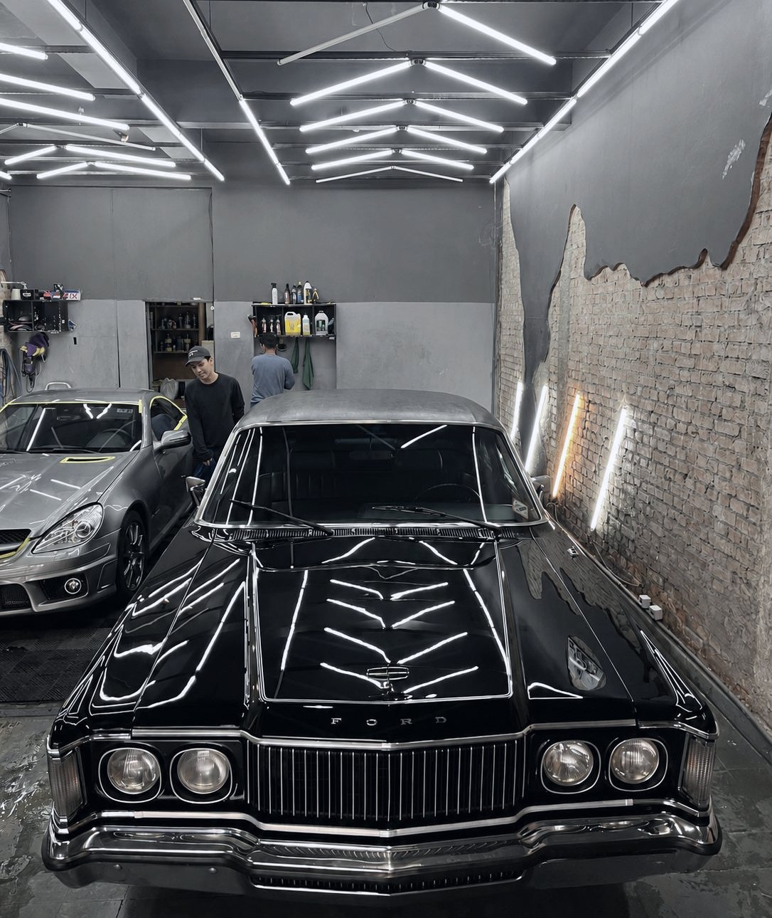 Ford Galaxie preto sob a matriz de LED na garagem de estética automotiva do Clube Drive, na Zona Oeste de São Paulo