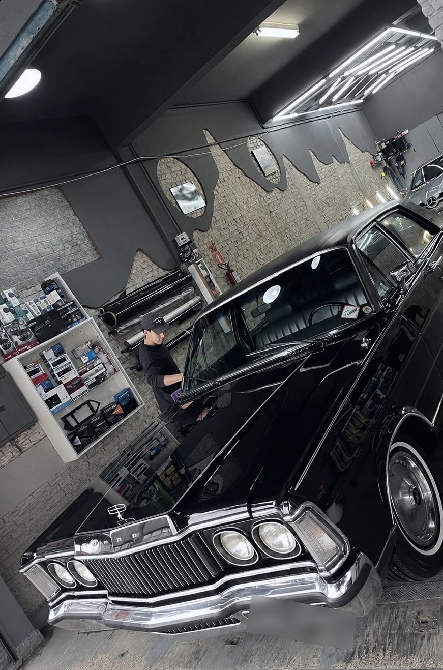 Profissional do Clube Drive trabalhando no para-brisa de um Ford Galaxie clássico